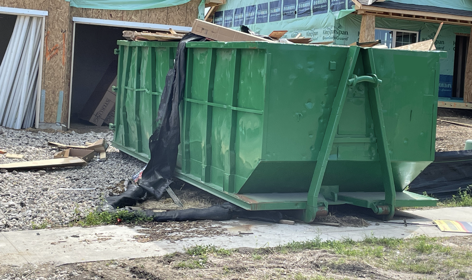Green dumpster placed at a new home building project site in Lakeville MN